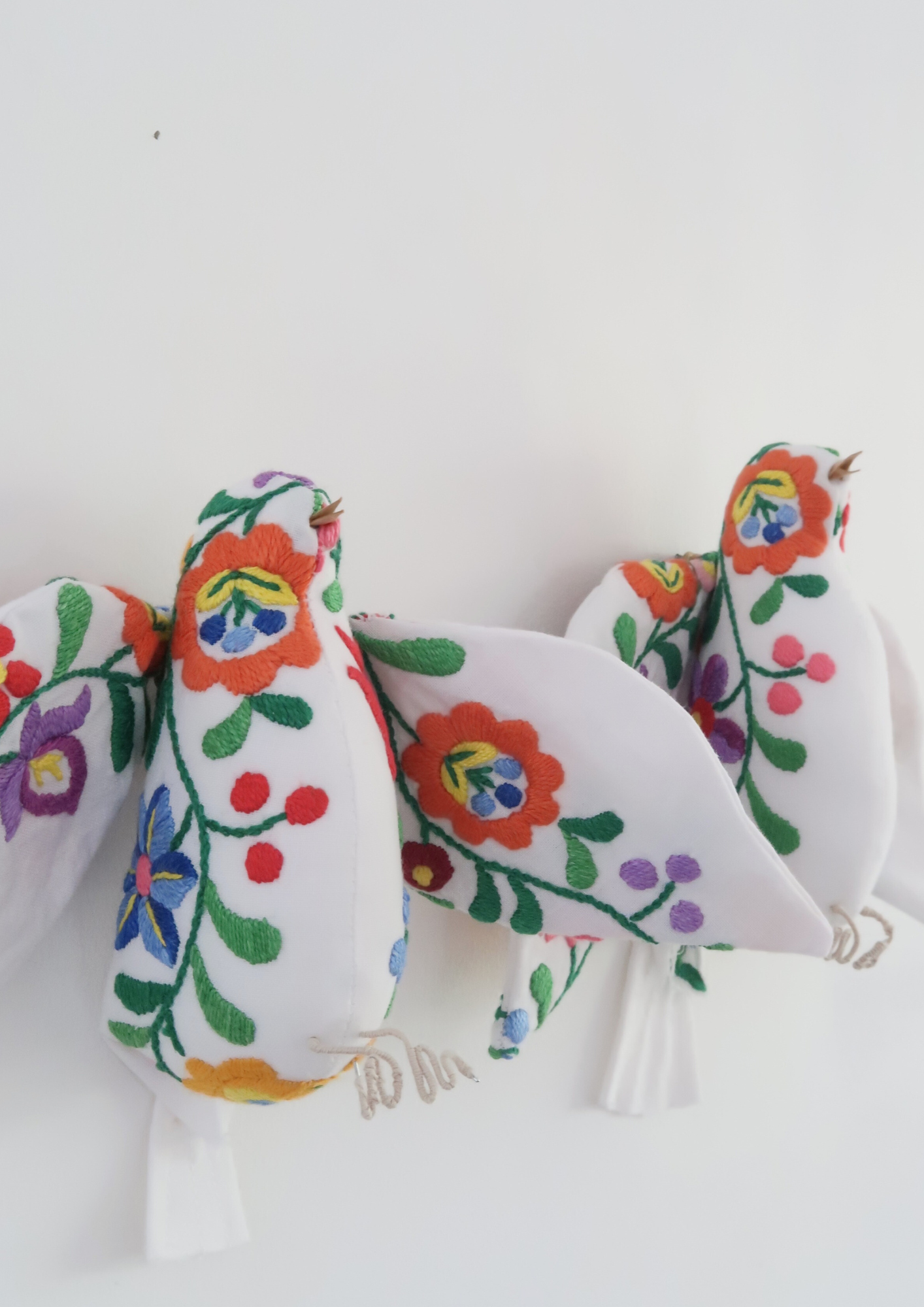 Petit oiseau brodé de fleurs colorées